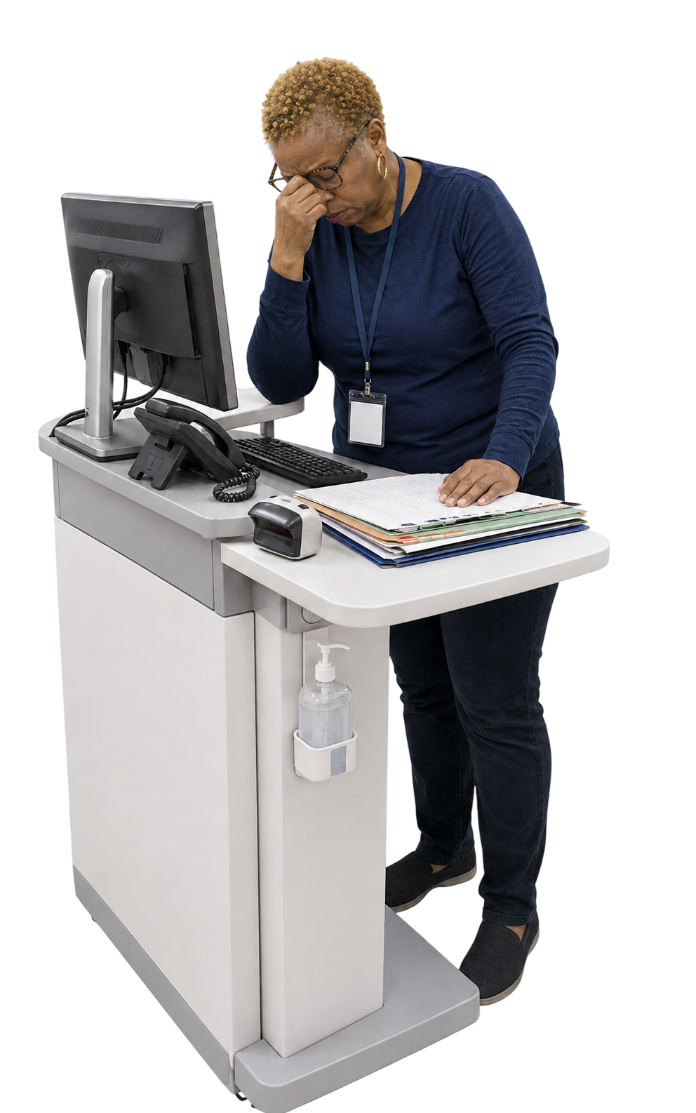 A staff member at a standing workstation, head in hand, over a stack of paper files